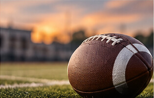 Football resting on a field at dusk